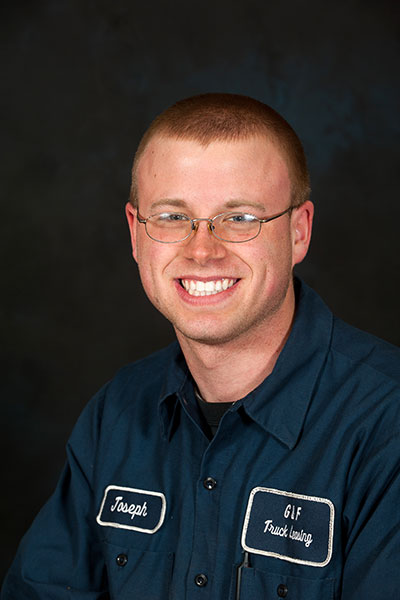 A man with glasses smiling for the camera.